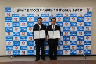 株式会社ニューフジフーズサービスの代表と市長が災害協定書を持って記念撮影している写真
