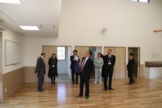 駒西小学校児童クラブの木造の室内を見学する市長と関係者の方達の写真