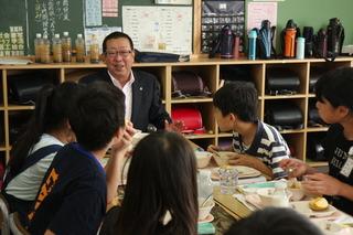 子供たちと一緒に楽しそうに給食を食べている市長の写真