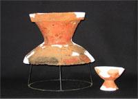 川崎遺跡から出土した弥生時代の赤茶色の壺の上部と高坏の写真