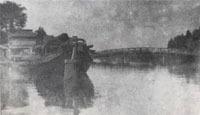 河川左側に荷船が停留し、中央から右側奥に養老橋が見える大正時代の白黒の写真