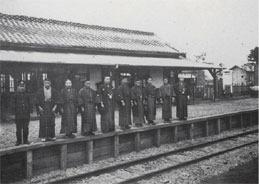 上福岡駅ホームの開業記念でホームに並んで写真撮影をする男性達の白黒写真