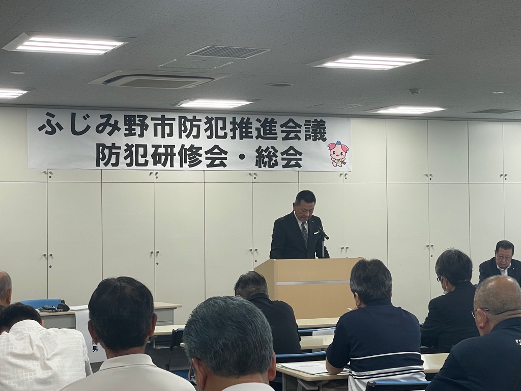 総会出席者を前に、議長が議事を進行している様子の写真