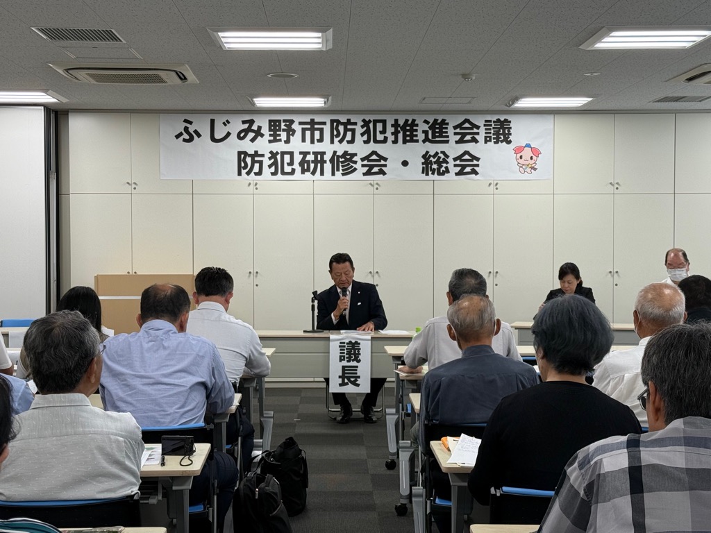 総会出席者を前に、議長が議事を進行している様子の写真